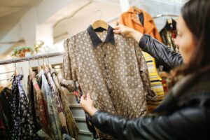 Woman holding shirt while shopping, woman shopping at thrift store, Style Degree, Singapore, SG, StyleMag.