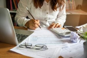 Woman calculating and writing on paper, Woman setting goals for home renovation, Style Degree, Singapore, SG, StyleMag.